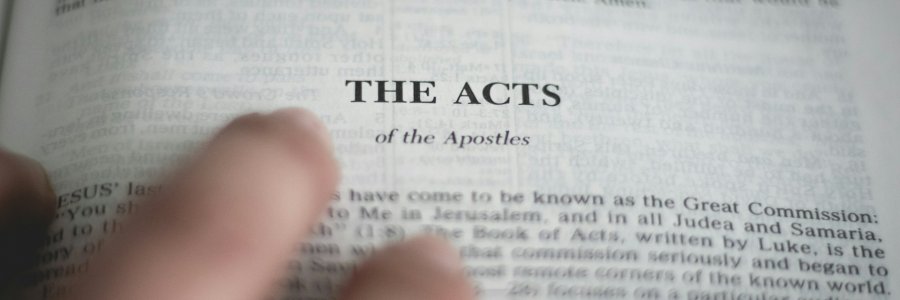 Photo shows the a close up of the first page of the Acts of the Apostles.